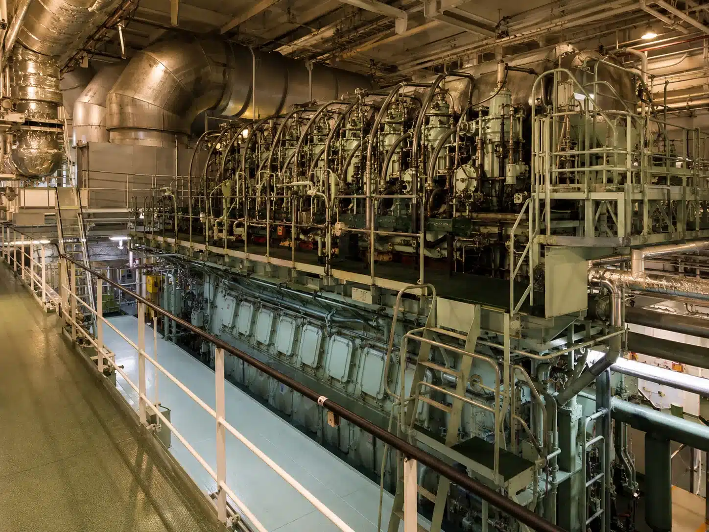 Engine room of a large vessel with main engine and piping